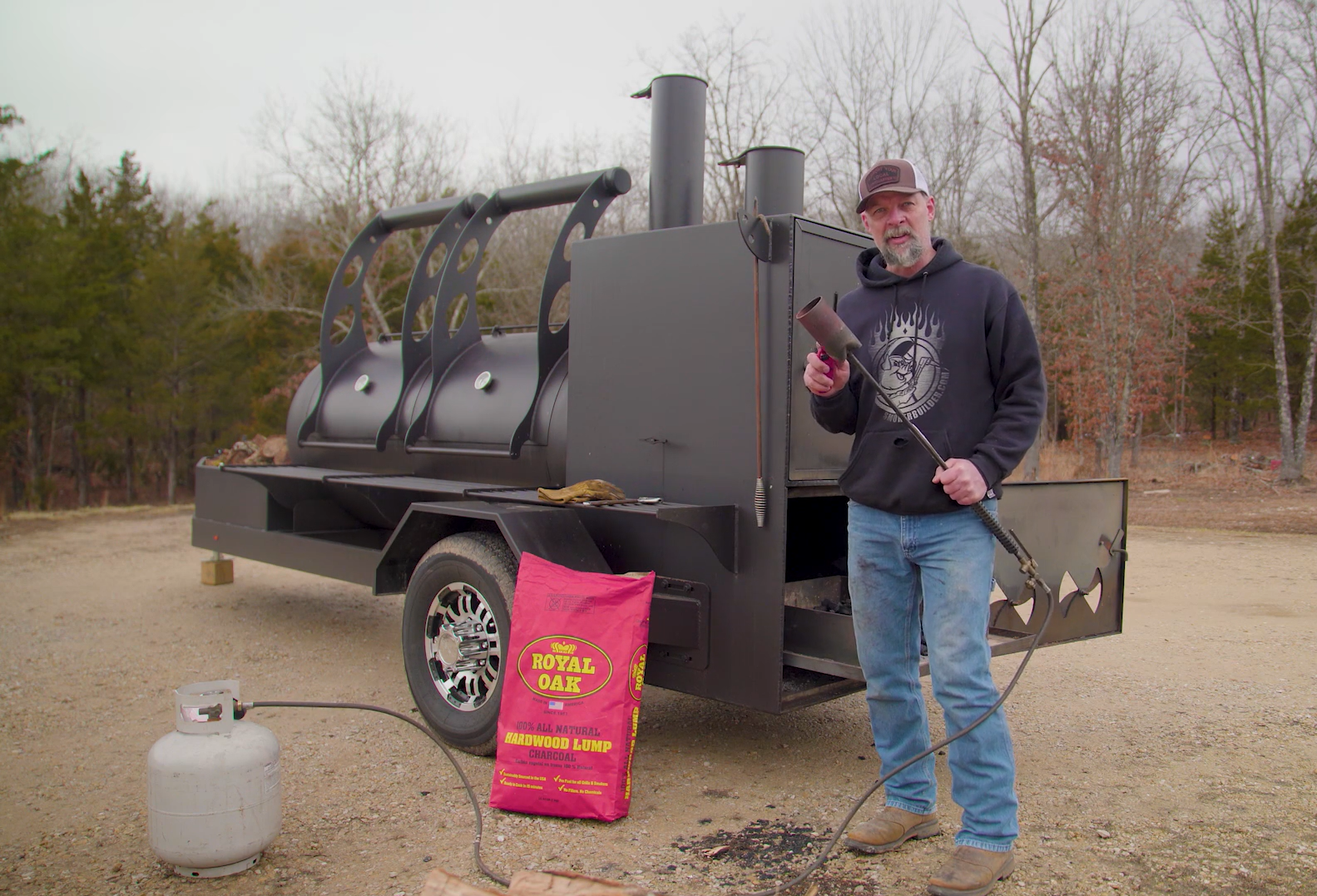 Frank Cox standing next to a trailer-mounted offset smoker