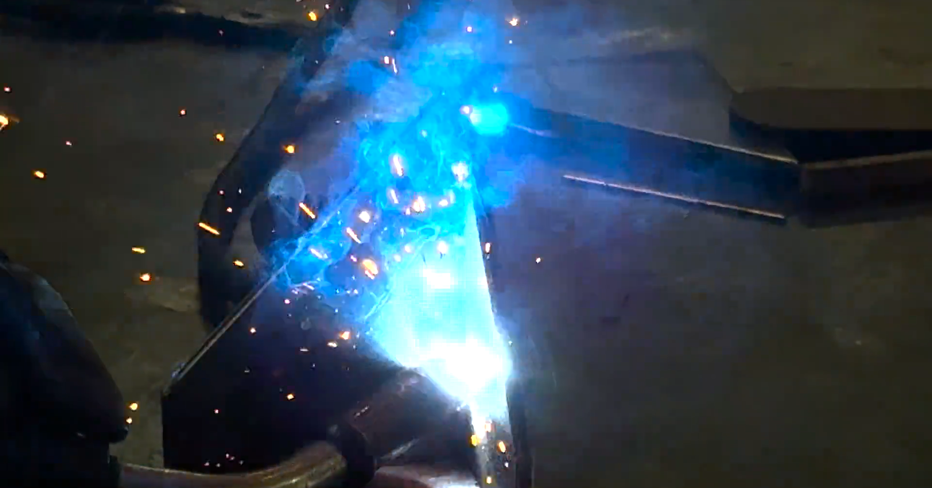 MIG welding a seam on steel plate with sparks flying