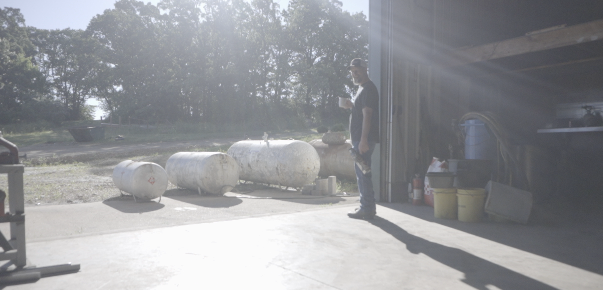 Used propane tanks lined up outside a shop