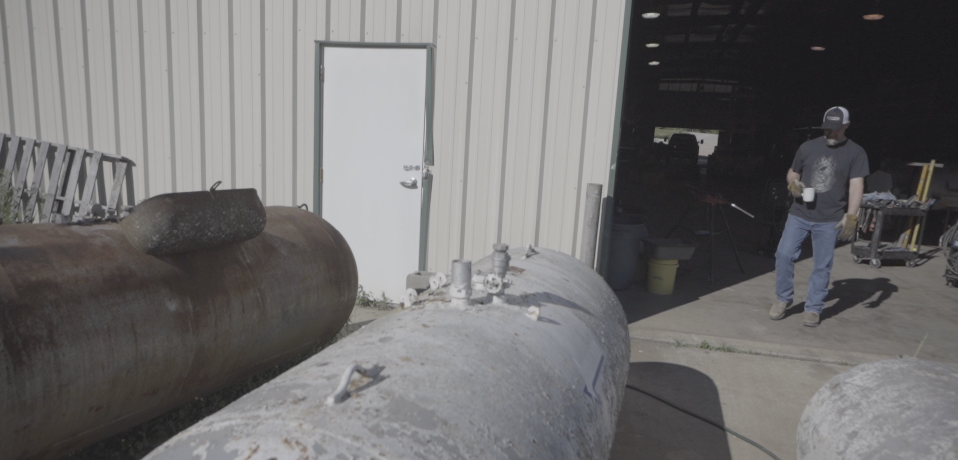 Used propane tank sitting on the ground outside a shop