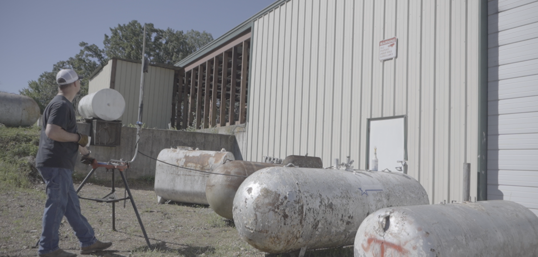 Used propane tanks lined up outside a shop