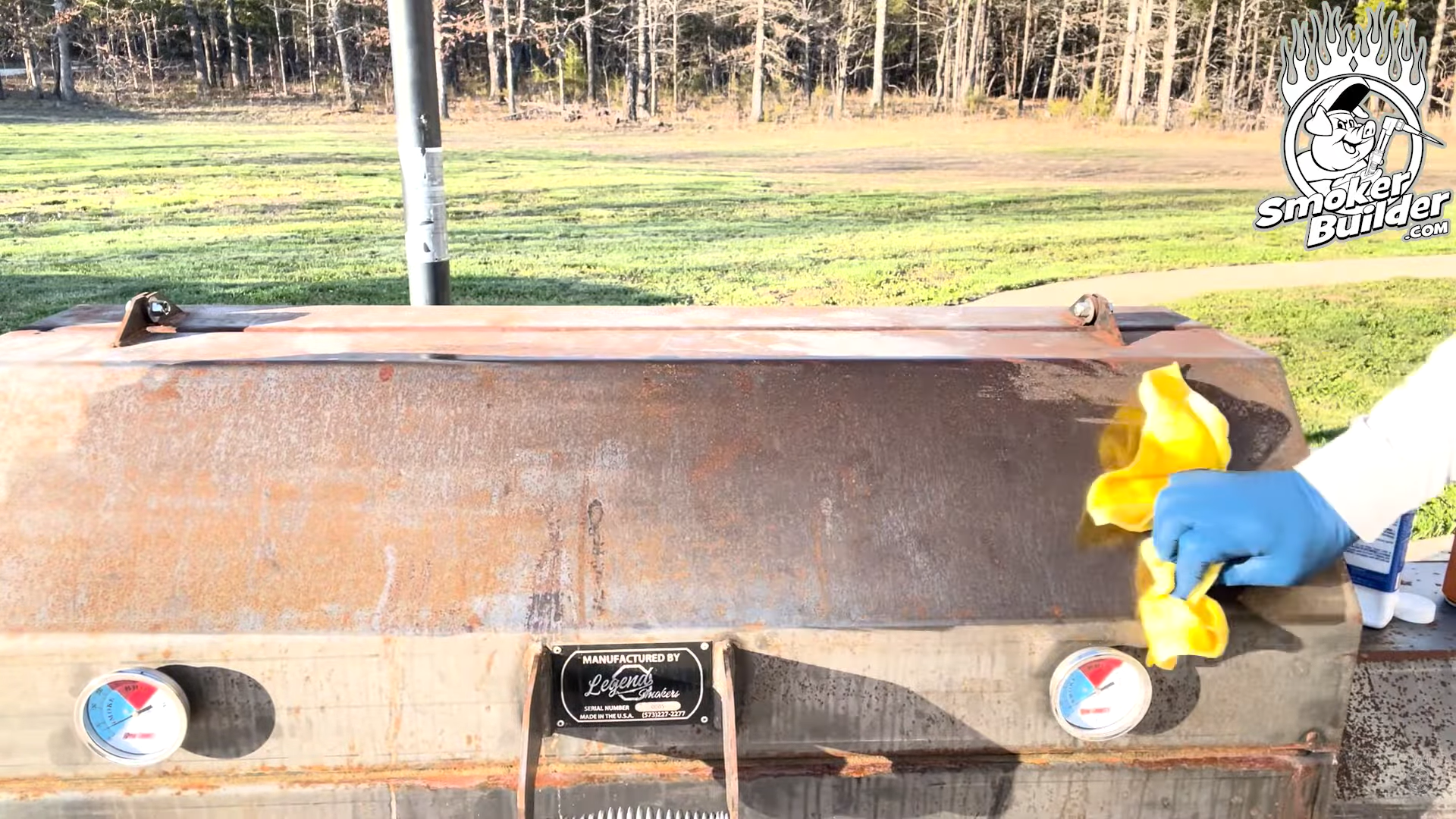 Wiping oil onto the bare steel of a finished smoker