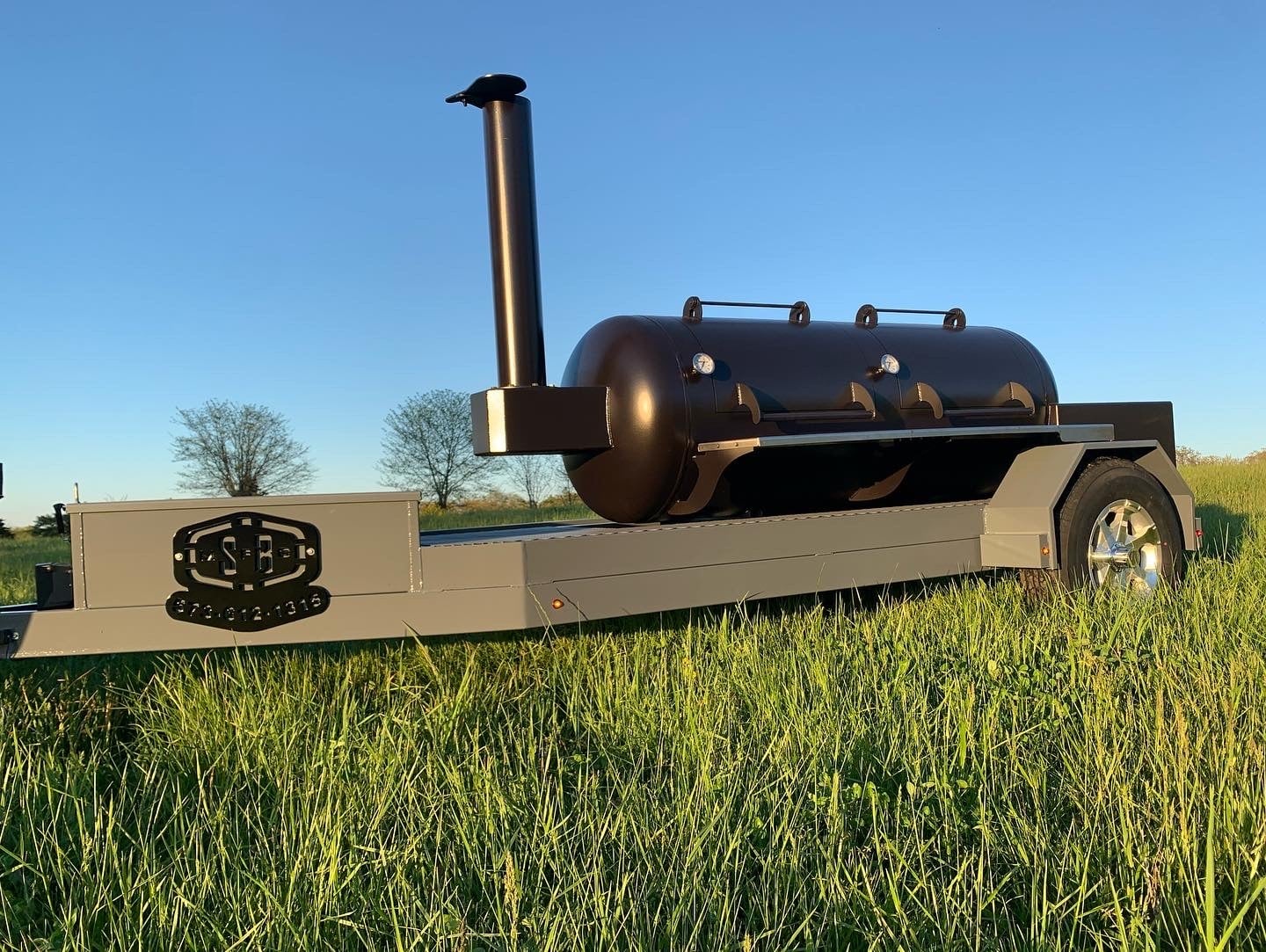 Finished propane tank offset smoker mounted on a trailer