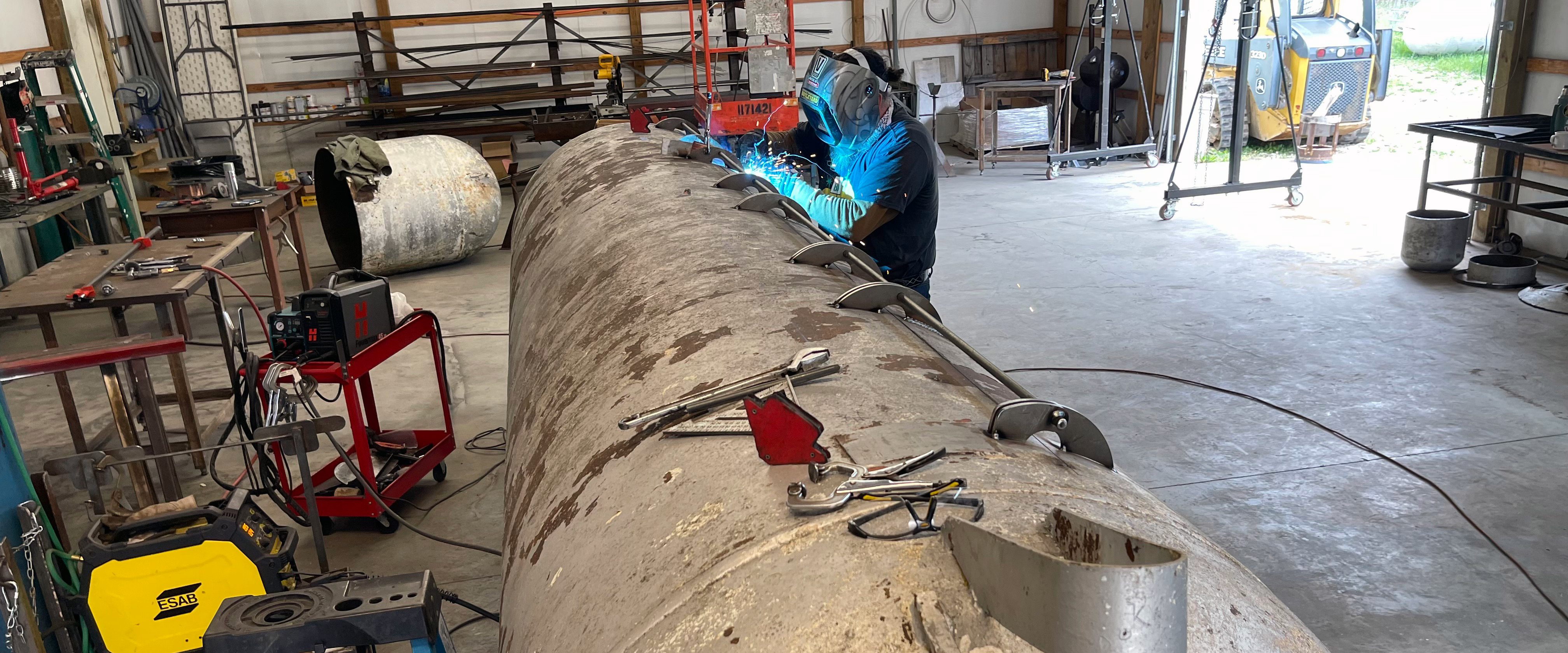Welding hinges onto the cook chamber doors of a tank smoker